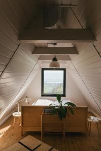 a room in a attic with a bed and a window at Kanyar - Nordic Cabin in Zebegény