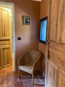 einen Korbstuhl in einem Zimmer mit Fenster in der Unterkunft Cévennes - Splendide chambre d'hôtes, indépendante et moderne in Monoblet