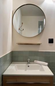 ein Bad mit einem Waschbecken und einem Spiegel in der Unterkunft Cévennes - Splendide chambre d'hôtes, indépendante et moderne in Monoblet