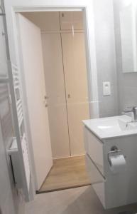 a white bathroom with a shower and a sink at Studio Adèle, op en top comfort & kwaliteit in Middelkerke