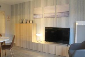 a living room with a flat screen tv on a entertainment center at Studio Adèle, op en top comfort & kwaliteit in Middelkerke