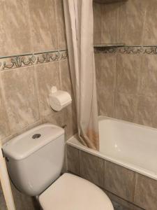 a bathroom with a white toilet and a bath tub at Appartement Arenales del sol in Arenales del Sol