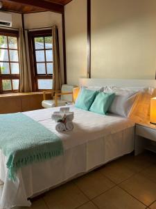 a bedroom with a large bed with blue and white pillows at Chalé das Águas in Igaratá