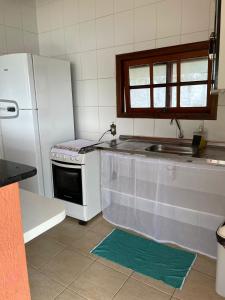 a kitchen with a white refrigerator and a sink at Chalé das Águas in Igaratá