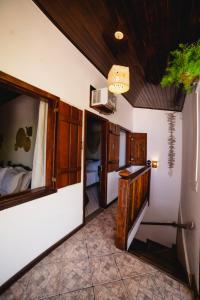 - un couloir avec une chambre dotée d'un lit et d'un miroir dans l'établissement Samburá Paraty, à Parati