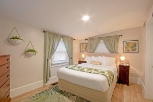 een slaapkamer met een groot bed en 2 ramen bij Hemingway House Bed and Breakfast in St. Augustine