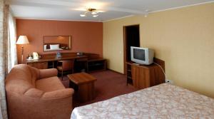 a hotel room with a bed and a desk and a television at Lovech Hotel in Ryazan