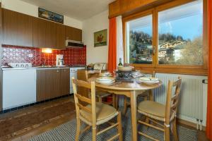 a kitchen with a wooden table with chairs and a window at Appartement Richemont 124 in La Tzoumaz