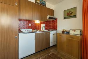a small kitchen with wooden cabinets and a sink at Appartement Richemont 124 in La Tzoumaz