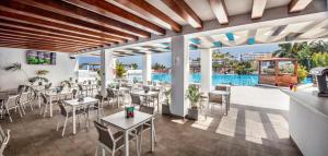 a restaurant with tables and chairs and a pool at Fuerteventura Princess in Playa Jandia