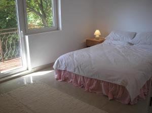 ein Schlafzimmer mit einem weißen Bett und einem Fenster in der Unterkunft Villa Rosa in Donji Morinj