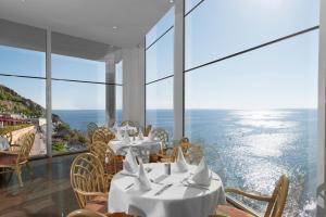 a restaurant with tables and chairs and a view of the ocean at Mogan Princess & Beach Club in Taurito