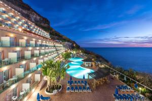 an aerial view of a hotel with a pool and the ocean at Mogan Princess & Beach Club in Taurito