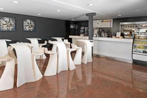 a row of white chairs in a restaurant with a counter at Mogan Princess & Beach Club in Taurito