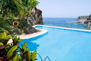 a swimming pool with a view of the ocean at Mogan Princess & Beach Club in Taurito