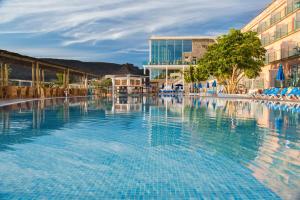 a large swimming pool in a resort with buildings at Mogan Princess & Beach Club in Taurito