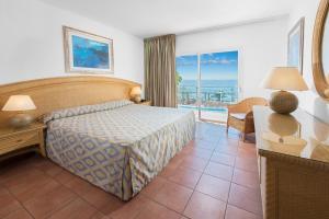 a bedroom with a bed and a view of the ocean at Mogan Princess & Beach Club in Taurito