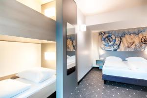 ein Schlafzimmer mit 2 Betten und einem Wandgemälde in der Unterkunft B&B Hotel Emden in Emden
