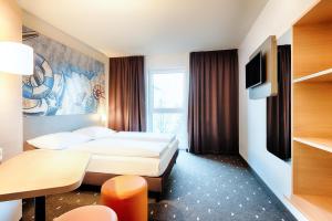 ein Hotelzimmer mit 2 Betten und einem TV in der Unterkunft B&B Hotel Emden in Emden
