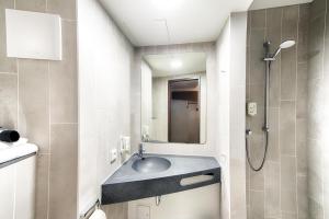 a bathroom with a sink and a shower at B&B Hotel Emden in Emden