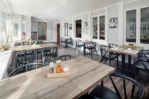 a dining room with wooden tables and chairs at Hotel am Denkmal Norderney in Norderney