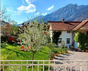 una casa con un árbol en un patio con una valla en Villa Rosen - Ferienwohnungen, en Bad Reichenhall