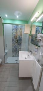 a bathroom with a white sink and a shower at Sicilia Bedda Taormina in Taormina +23 photos
