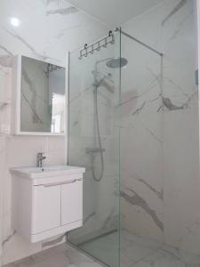y baño con ducha acristalada y lavamanos. en Beautiful apartment in Tivat en Tivat