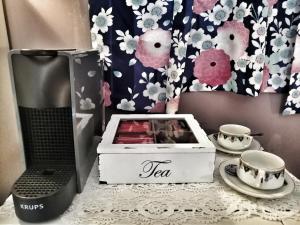 einen Tisch mit einer Teebox und zwei Tassen darauf in der Unterkunft RaMaya casa d'artista 2 THE ROOM in Biella