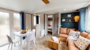 sala de estar con sofá y mesa en Camping Officiel Siblu Les Sables du Midi, en Valras-Plage