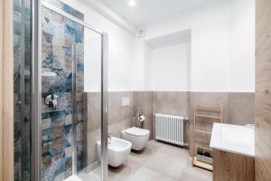 a bathroom with a toilet and a glass shower at Diaz 67 Life's Loft - The House Of Travelers in Como