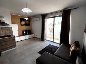uma sala de estar com um sofá e uma grande janela em Mediterranea 2 Bedroom Smart Apartment em St. Paul's Bay