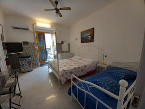 1 dormitorio con 2 camas y ventilador de techo en Casa Campisi i Mori, en Marzamemi