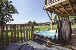 a hot tub on a deck with a gazebo at Sweeney Farm Glamping in Oswestry