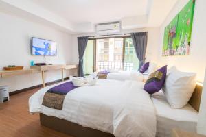 ein Hotelzimmer mit einem großen weißen Bett und einem Fenster in der Unterkunft Peacock De Pai Hotel in Pai