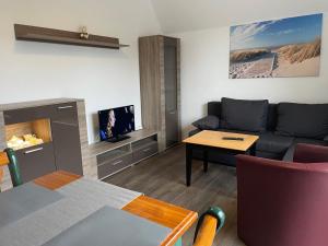 a living room with a couch and a tv at Strandhaus am Kurpark in Cuxhaven