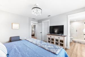 a bedroom with a blue bed and a television at Brand New Bungalow with King Bed Suites in St Aug in St. Augustine