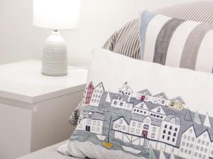 a pillow with a drawing of houses on it on a bed at Apartment 6 in Llandudno