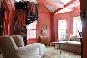 a living room with red walls and a spiral staircase at The Porches Inn at Mass MoCA in North Adams