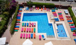 uma vista aérea de uma piscina com espreguiçadeiras e uma piscina em Medplaya Hotel Santa Monica em Calella