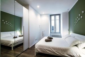 a bedroom with two beds and a mirror at Diaz 67 Life's Loft - The House Of Travelers in Como