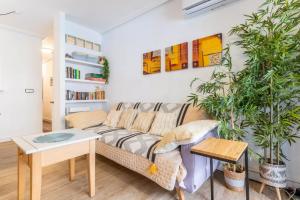 a living room with a couch and two potted plants at 098 Apartamento acogedor con el balcón y wifi in Torrevieja
