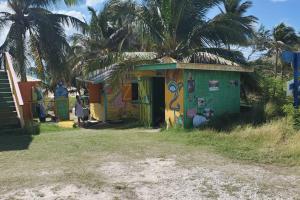 a small house with graffiti on it on a beach at Gloria's mini hideaway in Christ Church