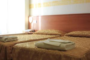 a hotel room with two beds with towels on them at Hotel Bellevue in Genoa
