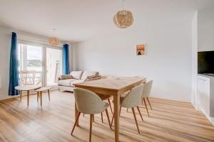 uma sala de estar com uma mesa e cadeiras e um sofá em Très belle appartement haut standing em Lacanau-Océan