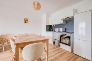 uma cozinha com mesa e cadeiras num quarto em Très belle appartement haut standing em Lacanau-Océan