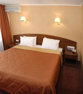 Habitación de hotel con 1 cama con 2 mesitas de noche en Lovech Hotel, en Riazán