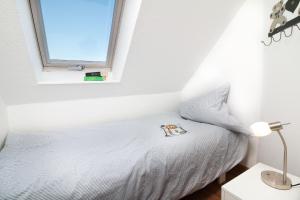 グレーミッツにあるW6 - Gästehaus Christian-Westphal-Str 60 - FERIENDOMIZIL HOLLICHのベッドルーム1室(窓、白いベッド1台付)