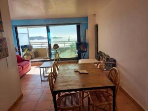 comedor con mesa y sillas con vistas al océano en Appartement d'une chambre a Quiberon a 200 m de la plage avec vue sur la mer balcon et wifi, en Quiberon