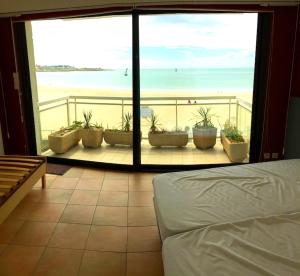 a bedroom with a view of the beach from a balcony at Appartement d'une chambre a Quiberon a 200 m de la plage avec vue sur la mer balcon et wifi in Quiberon